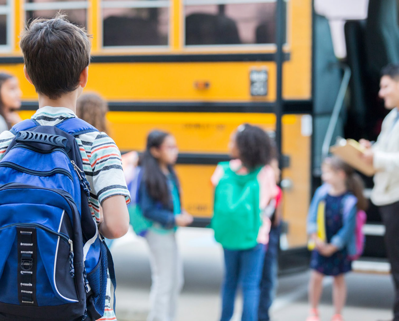 Children boarding electric school bus in the US.