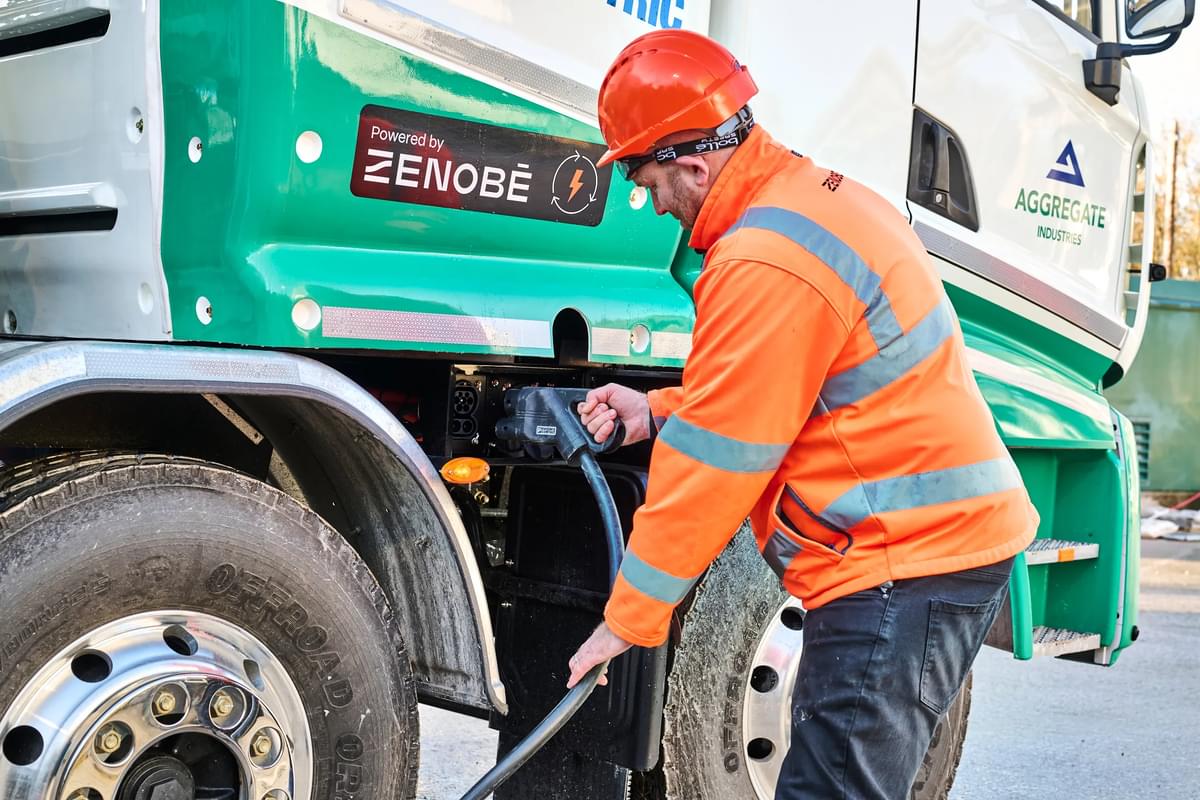 Man plugging a charger into an electric cement mixer