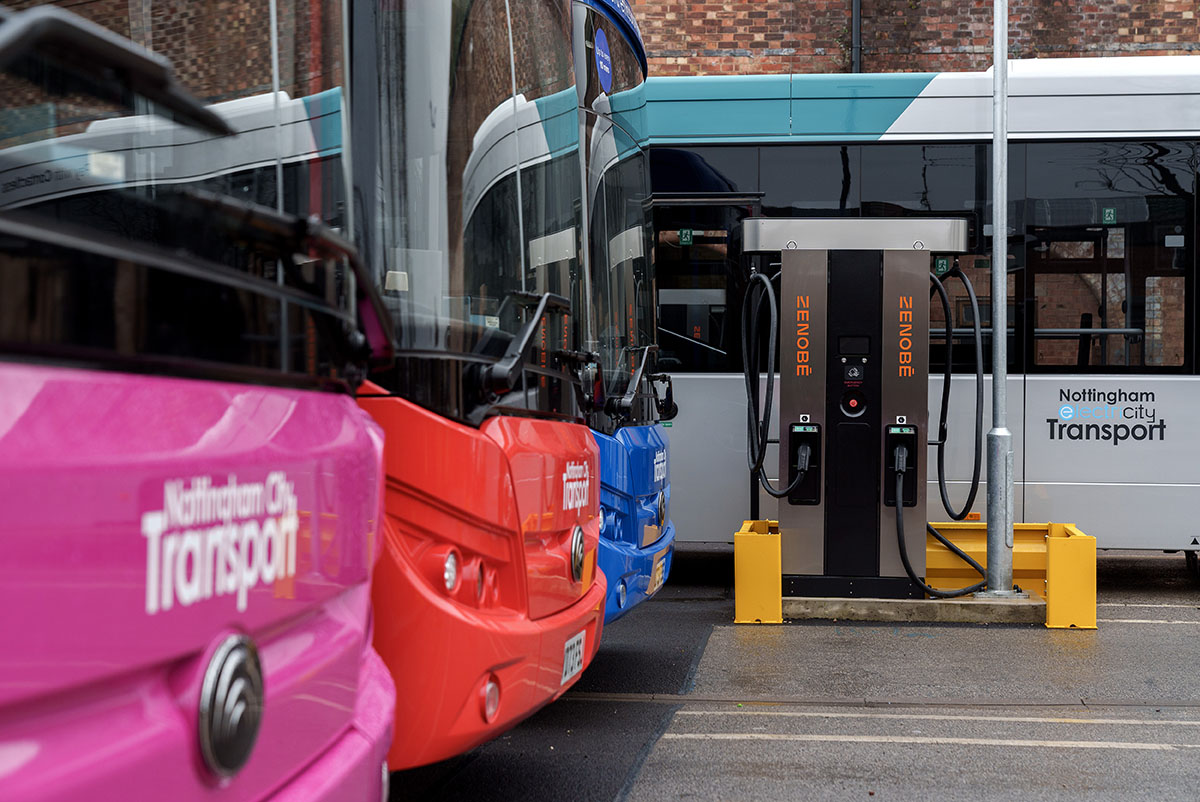 Electric Nottingham City Transport buses parked in a bus depot next to a Zenobe charger