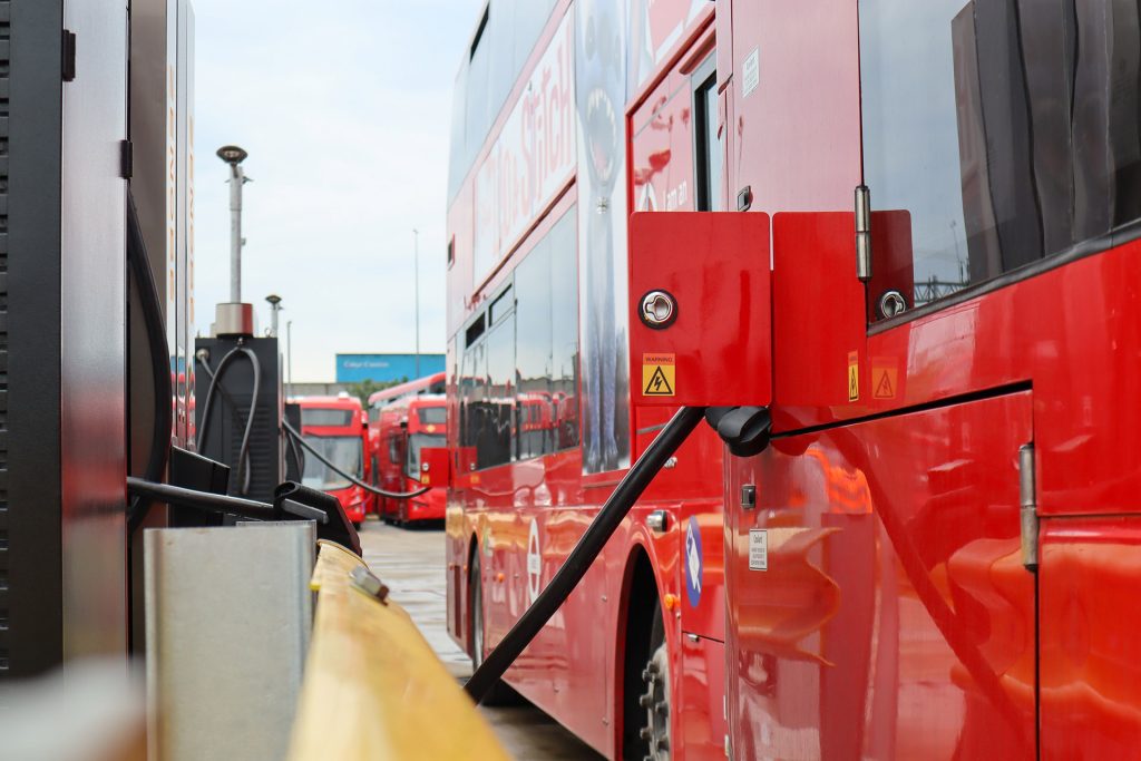 Electric bus being plugged into charger
