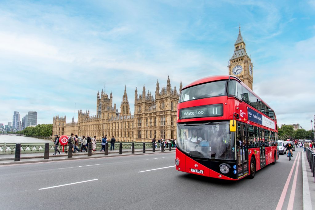Image of a red London bus in front of the Houses of Parliament, London